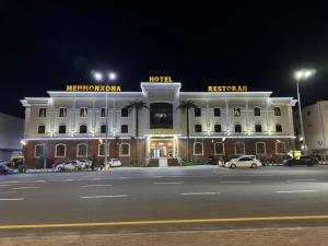 un hotel de noche con coches aparcados delante de él en Zilol Baxt Hotel, en Samarkand