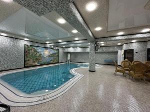 a large swimming pool in a building with at Zilol Baxt in Samarkand