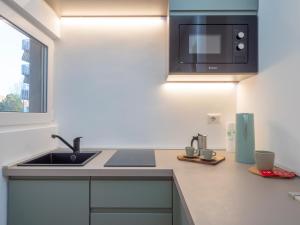 a kitchen with a sink and a microwave at Renovated studio apartment - Navigli area in Milan