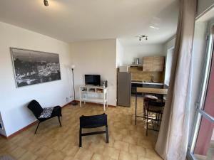 una camera con cucina e un soggiorno con sedie di Appartamento 44 a Novara