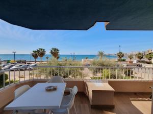 einen Balkon mit Tisch und Stühlen sowie Strand in der Unterkunft Apartamento Sunrise Beach in Fuengirola