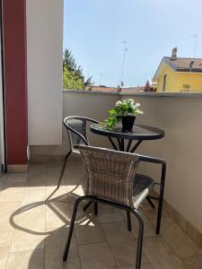 a table and chairs on a balcony with a plant at Appartamento 44 in Novara