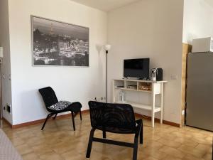 sala de estar con 2 sillas y nevera en Appartamento 44, en Novara