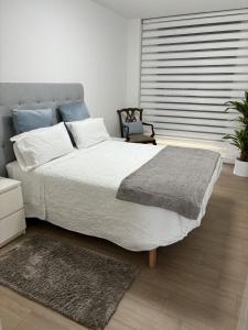 a bedroom with a large bed and a chair at El Mirador Ría de Vigo, apartamento frente al mar, céntrico in Moaña