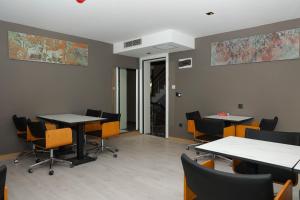 a meeting room with tables and chairs in a building at Gardenmode Airport Hotel in Taşoluk