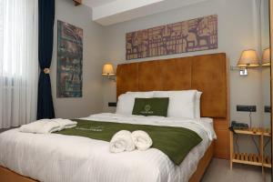 1 dormitorio con 1 cama grande y toallas. en Gardenmode Airport Hotel, en Taşoluk