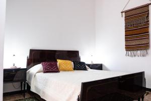 Sa Burra Guest House في Gadoni: غرفة نوم مع سرير مع وسائد ملونة