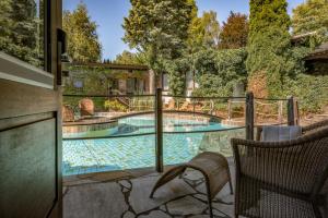 a swimming pool with two chairs on a patio at Hotel Land Gut Höhne in Mettmann