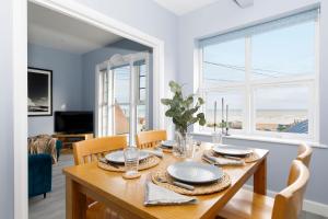 a dining room with a table and chairs with a view of the ocean at Chic 2-Bed Seafront Haven Near Felpham Beach in Felpham