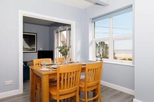 a dining room with a table and chairs and a window at Chic 2-Bed Seafront Haven Near Felpham Beach in Felpham +32 photos