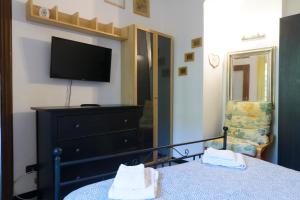 a bedroom with a bed and a tv and a dresser at Fattore 8 in Levanto