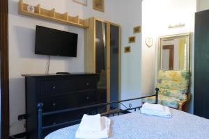 Schlafzimmer mit einem Bett, einem TV und einer Kommode in der Unterkunft Fattore 8 in Levanto