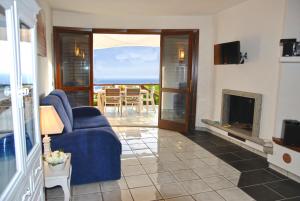 a living room with a blue couch and a fireplace at VILLA ROMANTIC COVE vista mozzafiato sul mare in Latina