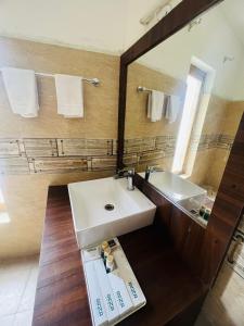 y baño con lavabo blanco y espejo. en Guza Ethnic Resort, en Leh