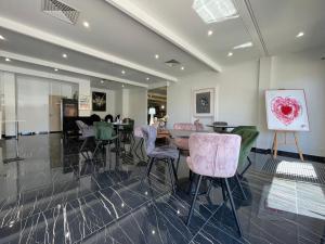 a room with a table and chairs and a painting at Hôtel Napoléon in La Turbie