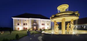 fontanna przed budynkiem w nocy w obiekcie Golf&Wellness Resort Alfrédov w mieście Alfrédov