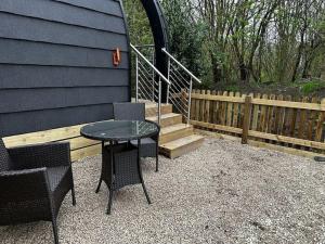 a patio with a table and chairs and a staircase at Badger at Owlet Hideaway - with Hot Tub, near York in Seaton Ross