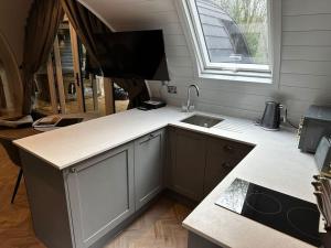 a kitchen with a counter and a sink and a window at Badger at Owlet Hideaway - with Hot Tub, near York in Seaton Ross