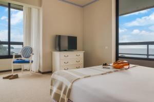 a bedroom with a bed and a television and a chair at Pestana Bahia Praia Nature & Beach Resort in Vila Franca do Campo