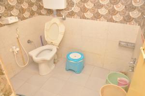 a bathroom with a toilet and a stool in it at Chitrakut Bungalows in Dwarka +24 photos