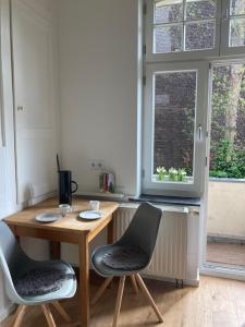 een kamer met een tafel, 2 stoelen en een raam bij 3 Zimmer-Lounge in KÖLN Sülz mit Küche, Balkon, 2 Bäder in Keulen