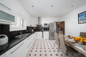a kitchen with white cabinets and a table with chairs at Family Holiday Villa with Pool in Albufeira