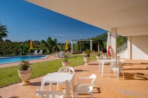 a patio with tables and chairs next to a pool at Family Holiday Villa with Pool in Albufeira