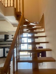 a wooden staircase in a house with a kitchen at Duplex near the Cleopatra Beach in Alanya in Alanya