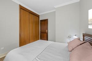 una camera con un letto bianco e una porta in legno di Piso Don Eduardo ad Arrecife