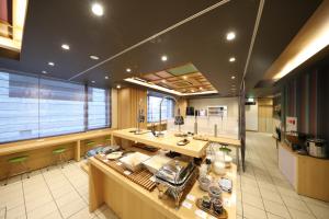 a large kitchen with a counter and a large window at Smile Hotel Kyoto Karasuma Gojo in Kyoto