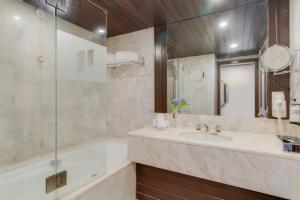 a bathroom with a tub and a sink and a shower at Pestana Bahia Praia Nature & Beach Resort in Vila Franca do Campo
