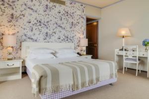 a bedroom with a white bed with a floral wallpaper at Pestana Bahia Praia Nature & Beach Resort in Vila Franca do Campo