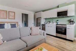 a living room with a couch and a kitchen at Blueground Oakland ac walk to dining shops SFO-1705 in Oakland