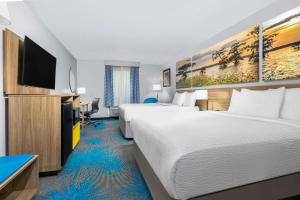 een hotelkamer met 2 bedden en een flatscreen-tv bij Days Inn & Suites by Wyndham Cabot in Cabot