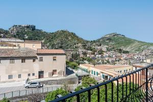 A Look of Taormina Apartments - a Few Steps from the Center في تاورمينا: اطلالة على مدينة فيها جبال في الخلفية