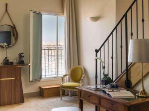 Camera con scrivania, sedia e finestra. di Grand Hotel Beauvau Marseille Vieux Port - MGallery a Marsiglia