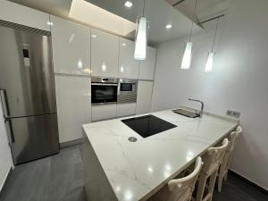 cocina con encimera blanca y nevera en Bungalow the Paradise, en Maspalomas