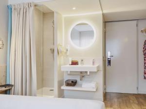 La salle de bains est pourvue d'un lavabo et d'une douche. dans l'établissement ibis Thalassa Hyeres Plage, à Hyères