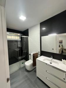 Un baño con inodoro, lavabo y ducha. en Bungalow the Paradise, en Maspalomas