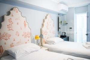 Duas camas num quarto com paredes azuis em Americana Hotel em Londres
