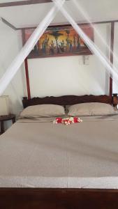 a bedroom with a bed with flowers on it at BeB Sardegna2 Anjumasa village in Watamu