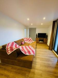 uma sala de estar com um sofá com um cobertor em Residence les isards em Formiguères