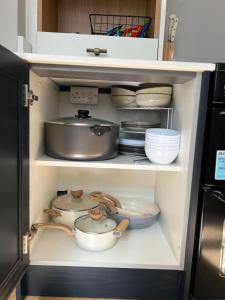 a cabinet filled with bowls and pans and plates at The hidden cottage in Wythenshawe