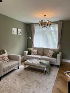 uma sala de estar com um sofá e uma mesa em The hidden cottage em Wythenshawe