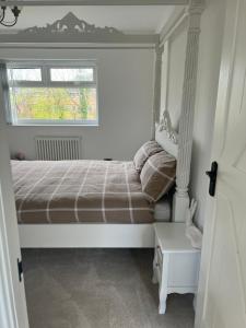 a small bedroom with a bed and a window at The hidden cottage in Wythenshawe