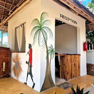a mural of a man walking past a palm tree at TIANDE Boutique Hotel in Pwani Mchangani