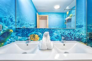 a bathroom with two sinks with an ocean theme at Sol Mogan Suites - Adults Only in Puerto de Mogán
