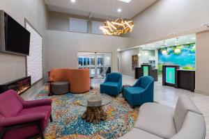 a lobby with a waiting room with chairs and a tv at La Quinta by Wyndham New Braunfels in New Braunfels