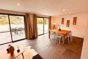 un soggiorno con tavolo e sedie e un balcone di Escapade Ardenne: 16 pers a Esneux