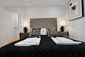 a bedroom with a large black bed with two lamps at Super Central 3 bed in Richmond in Richmond
